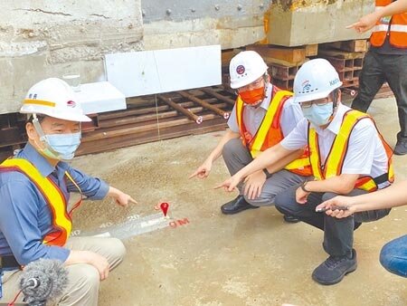 交通部長王國材(中)、立委李昆澤(右一)及交通部官員一行人26日見證高雄帝冠車站啟動遷移回娘家。圖中紅色箭頭處為車站建築體開始啟動的位置,將先向北挪移4.8公尺,再向西挪移57.86公尺後,完成永久定位。(石秀華攝)