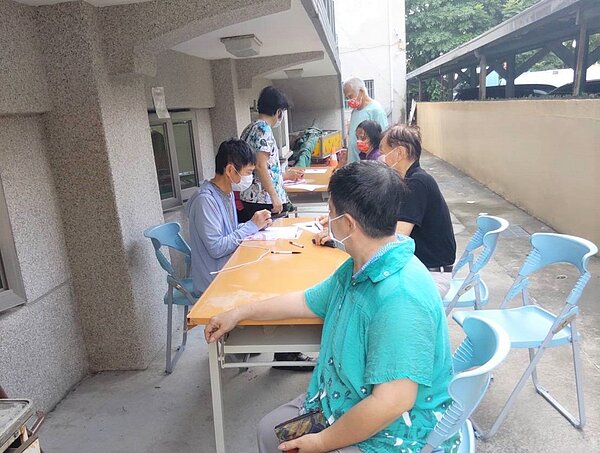 台南市麻豆區東角里有志工協助長輩上網登記及預約1922。圖／東角里長提供