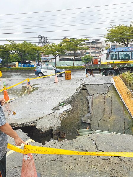 鳳山區五甲二路旁水溝上的水泥覆蓋地坍塌,警方到場後拉起封鎖線、管制人員進出安全,並立即通報水利局人員到場處理。(翻攝畫面/洪浩軒高雄傳真)