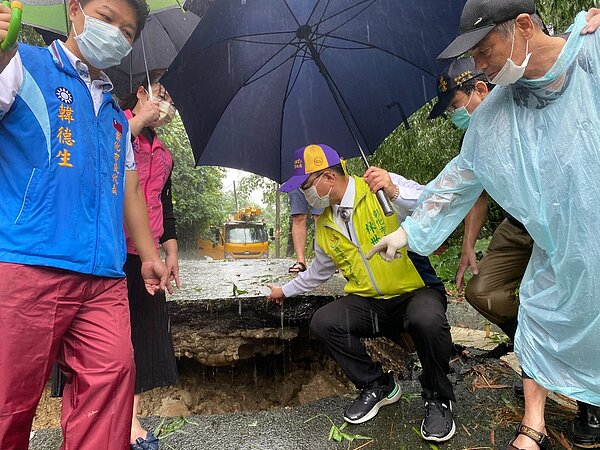 彰化市八卦山區的安溪路591巷有兩戶人家,今天清晨因土石流造成住宅庭院及圍牆滑落,道路被掏空,陷落約60公分,無法通行,市長林世賢(右2)冒雨前往勘察。記者劉明岩/攝影