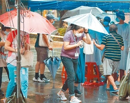 國內疫情未解，亟需疫苗防疫，慈濟透露與民間企業購買首批BNT疫苗最快9月到貨。圖為新北市永和區某社區群聚案，機動快篩隊進駐當地，民眾13日在完成快篩後，突然遇上豪大雨。（羅永銘攝）