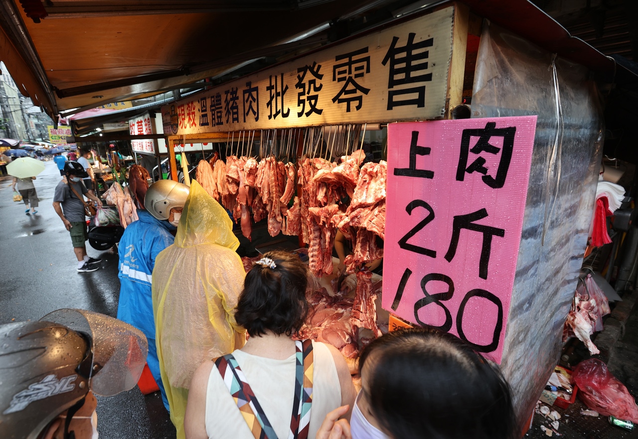 不少民眾昨天下午前往傳統市場，趕在休市前冒雨排隊買豬肉，成為奇特景象。記者林澔一／攝影