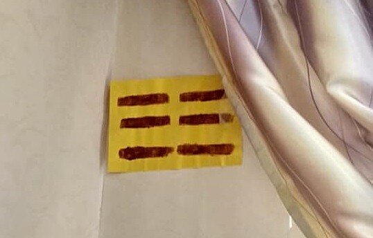 有網友發現窗簾底下貼著一張畫有6條紅橫線的黃紙。 圖/截自《靈異公社》