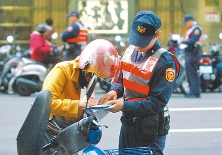 員警在路口對未依規定「兩段式左轉」的違規騎士開單告發。圖／中時資料照片