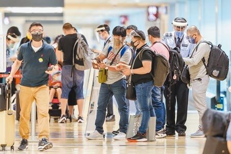 國際疫情嚴峻,國內17日一口氣新增14例境外移入個案,桃園機場許多入境旅客都穿著防護裝備。圖/記者陳麒全攝影