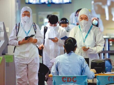 中央流行疫情指揮中心21日表示,即日起自帛琉入境旅客,新增入境後第12至14日須公費PCR檢測。圖為桃園機場第二航廈入境管制區剛下機的旅遊泡泡旅客,排隊查驗入境健康資料。(范揚光攝)