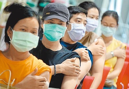 
疫情嚴重疫苗不足，人民得上網預約打疫苗。圖為北市花博爭豔館接種站完成施打的民眾，遵照醫護人員指示按壓手臂注射處。（本報資料照片）
