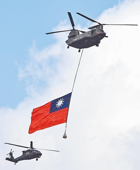 圖為109年國慶大會預演時，在北醫杏聲合唱團與防疫人員代表領唱國歌的同時，陸軍CH-47直昇機在黑鷹直升機的伴飛下，吊掛巨幅國旗進場。圖／中時資料照片