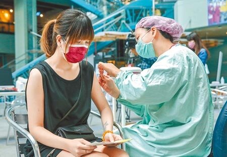 國產高端疫苗開打,預計將於本週完成7萬人接種。24日科教館的接種站內,護理人員正為民眾施打疫苗。(粘耿豪攝)