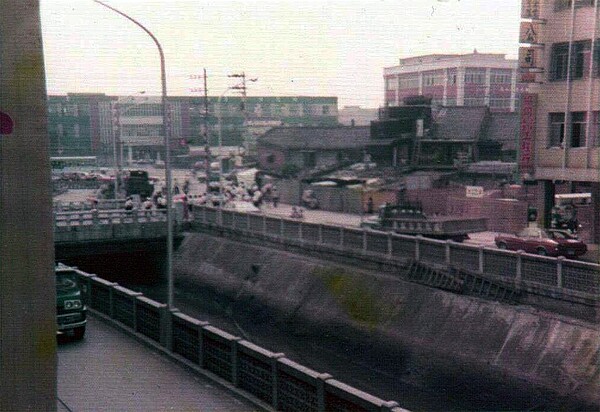 這是1970年代的臺北市西藏路街景,從雙園街與西藏路口往東拍攝;遠方左側的綠白建築是華江女子國中(今華江高中),右側的紅白建築是西園路派出所,可以看到當時西藏路中間的排水溝尚未加蓋。 (林文聰提供)