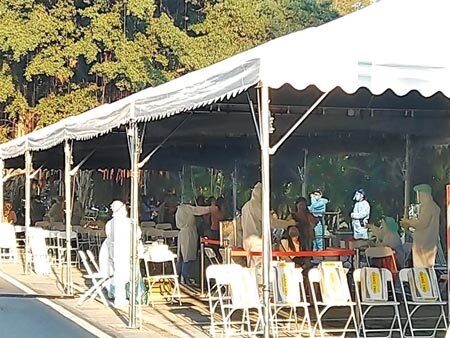 國巨楠梓廠一名員工確診新冠肺炎,公司其他員工神情鎮定排隊配合篩檢。(林雅惠攝)