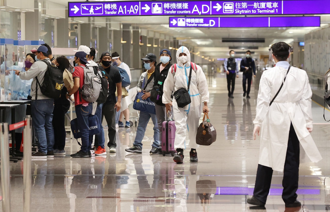 圖為入境旅客穿著全套防護衣，於入境長廊步行。記者黃仲明／攝影 