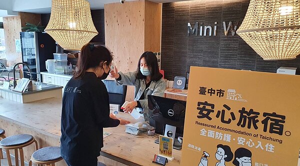 民眾入住「安心旅宿」量測體溫。圖/中市府提供