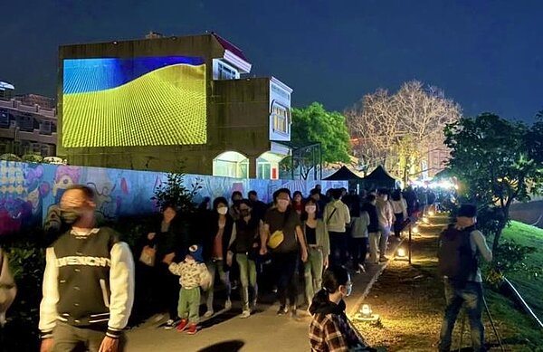 臺南市27日晚間起於鹽水月津港燈節水岸設置大型水岸投影，將烏克蘭國旗藍黃主色投影於藝術燈區，表達聲援。圖／台南市政府提供