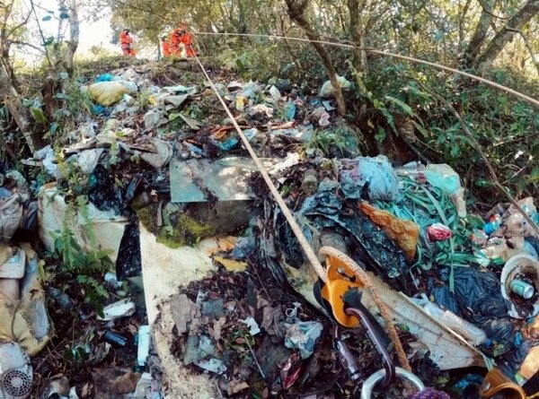 南投仁愛山區「垃圾瀑布」問題嚴重，志工為清理涉險垂降陡坡撿拾，清出約500公斤垃圾，數量驚人。圖／綠色和平基金會提供