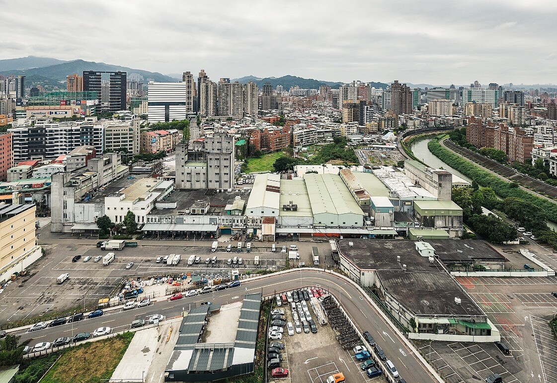 新店榮工單元2位於新店區東北隅，北側以景美溪為界與台北市文山區相鄰，計畫區內現況主要為正大尼龍工業之倉儲及辦公使用，而西側多為老舊低矮住宅，東側主要為停車場使用，南側為裕隆、宏達電等企業總部及大型賣場如家樂福等。圖／新北市府提供