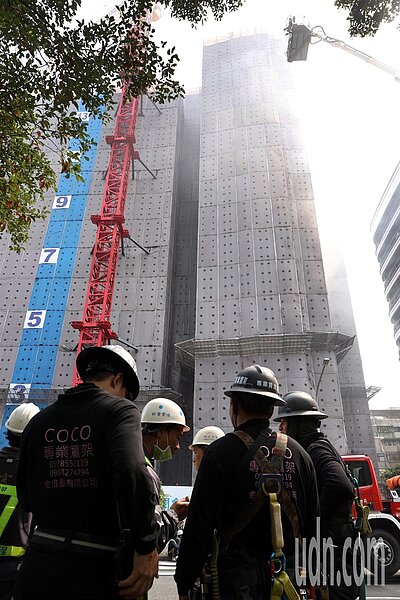 台北市大安區富邦大樓施工工地傳火警，疏散的施工人員站在分隔島議論紛紛。記者侯永全／攝影 