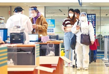 台北市某防疫旅館日前傳4人確診,感染源為一名香港入境住客。圖為在桃園機場第二航廈的入境管制區內,旅客排隊查驗入境檢疫憑證。(范揚光攝)