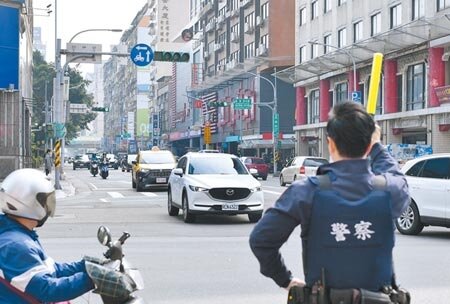 《道路交通管理處罰條例》修正案,明定警察得不再受理紅黃線臨停檢舉,但因行政院遲遲未公布施行日,造成仍有國人挨罰。圖為警方指揮交通。(本報資料照片)