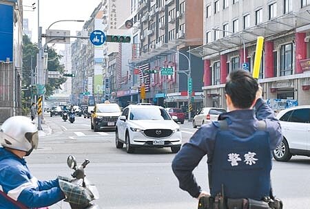 《道路交通管理處罰條例》修正案，明定警察得不再受理紅黃線臨停檢舉，但因行政院遲遲未公布施行日，造成仍有國人挨罰。圖為警方指揮交通。（本報資料照片）
