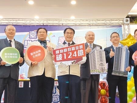 台南市長黃偉哲（中）12日抽出2間輕豪宅得主，他說，2021台南購物節消費登錄發票總金額逾124億元，較前1年成長近88％。（曹婷婷攝）