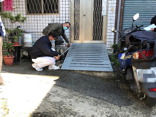 慈濟志工在獨居長者門口安裝斜坡,方便老人家搭乘輪椅出入。圖/讀者提供