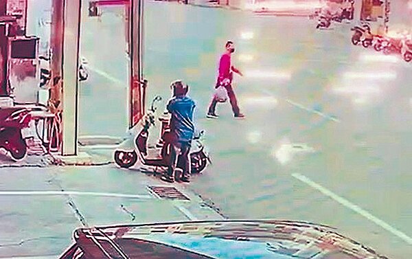 彭男在行凶後,手拎一包疑似放有凶刀物品,若無其事過馬路。圖/羅浚濱翻攝