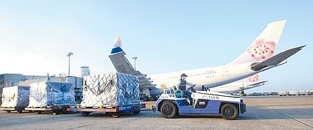 中華航空15日公告2021全年營收達新台幣1388.41億元,其中貨運收入更以1245億元創62年來最高紀錄,在桃園機場的停機坪上,地勤人員忙著卸下班機上的貨物。(范揚光攝)