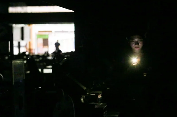 新店今早發生停電。圖為過去新店家樂福停電時,店員拿起手機手電筒站櫃情況。圖/聯合報資料照片