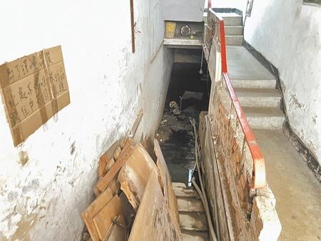 板橋和平路某公寓1樓樓梯間下方的防空避難空間,因長年積水導致蚊蟲滋生及散發惡臭,住戶苦不堪言。(王揚傑攝)