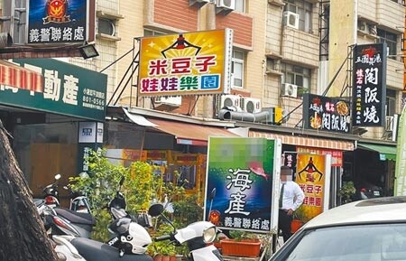 高雄小港區宏平路一間海產店，違規將招牌及盆栽放置於人行道上卻未遭取締，由於招牌上寫著「義警聯絡處」，不免讓民眾質疑是否有特權。（洪靖宜攝）