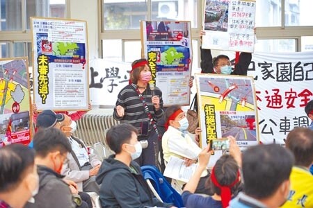 
台北客運因北大調度站租約屆期，近期向市府提出申請，遷移至國成街兩側空地，引發地方民眾反彈，近百位民眾昨日到公聽會陳情，高舉「台北客運先斬後奏」、「交通局掩護非法」牌子，呼籲市府駁回申請案。（蔡雯如攝）
