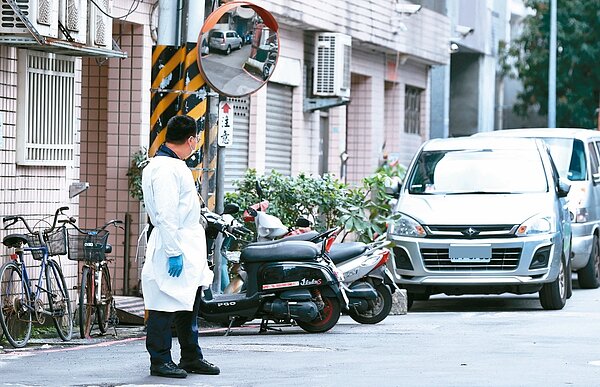 一名穿著隔離衣的員警在該棟公寓周邊的巷弄戒備。記者侯永全/攝影