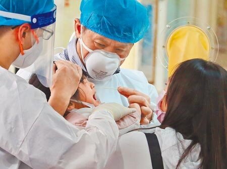 新北市中和景福里景福市民活動中心一連3天設機動篩檢站,加強防疫檢測。圖為民眾前往篩檢,1名小朋友嚎啕大哭,在家長與醫護人員協助下完成篩檢。(陳俊吉攝)