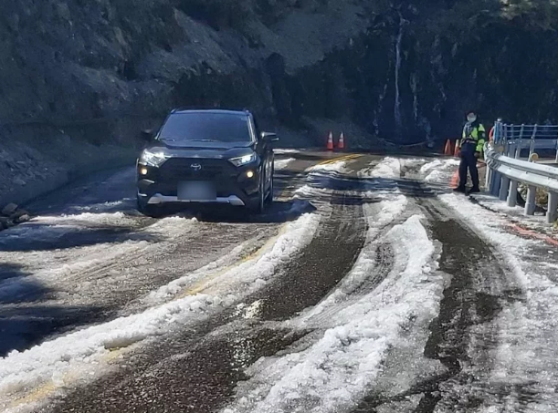 今天氣溫回升且未降雨，合歡山「水晶宮」路段卻因路旁側溝遭落石阻斷，雨水溢流路面而結冰，預估中午過後才能消融。圖／仁愛警分局提供
