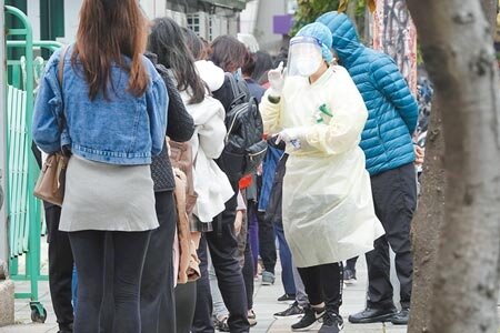 疫情燒進國防部,博愛營區有4名外包商和1名軍人染疫,都是無症狀或輕症。圖為新北市政府在清明連假期間仍開設社區篩檢站,工作人員身穿全套防護裝備協助民眾報到採檢。(黃世麒攝)