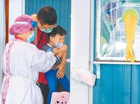 本土疫情蔓延,在清明連假過後,6日新北市板橋區江翠篩檢站,一位小朋友在篩檢後不耐疼痛嚎啕大哭。(粘耿豪攝)