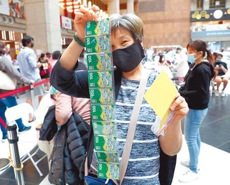 為了提高長者施打新冠肺炎疫苗意願,台北市政府7日起對設籍台北市65歲以上的民眾,只要於北市合約醫療院所及中型接種站接種疫苗1、2劑、基礎加強劑或追加劑,除中央給的500元禮券外,再加碼500元禮券,共可獲得1000元禮券。一位民眾7日在台北火車站廣場的接種站施打新冠肺炎疫苗後,高興的展示領到的1000元超商禮券。(鄭任南攝)