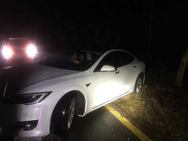 百萬特斯拉車輪陷泥濘受困山區產業道路。圖/苗栗縣府提供