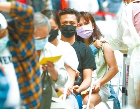 中央近期啟動「新台灣防疫模式」,強調以減災為目標,不追求全面清零、也不放任病毒肆虐。台北市長柯文哲昨日說,現階段不要再糾結於名詞。圖為台北車站的疫苗接種站,午後有不少外籍人士前往施打疫苗,一位民眾在注射時露出痛苦表情。(粘耿豪攝)