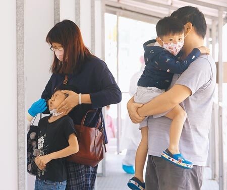 本土新冠肺炎疫情持續升溫,16日單日新增1199例,境外移入152例,無死亡病例首見未滿5歲童併發重症,週末假期首日,一對夫婦帶著小朋友至社區篩檢站篩檢。(陳怡誠攝)