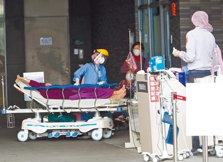 繼新北市啟動居家照護後，宜蘭縣長林姿妙、高雄市長陳其邁也宣布將啟動居家照護。圖為新北市市立土城醫院急診室醫護人員全套防護裝備進行病患的診治。(陳怡誠攝)