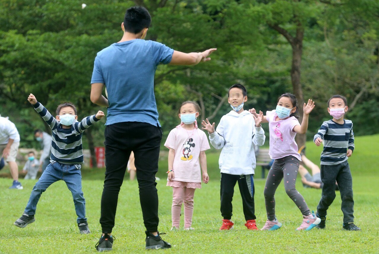 食藥署通過6至11歲的莫德納緊急使用授權，專家說兒童接種後的副作用以局部疼痛和疲倦為主。圖為一群小朋友在公園玩球，未來有疫苗可打了。記者胡經周／攝影