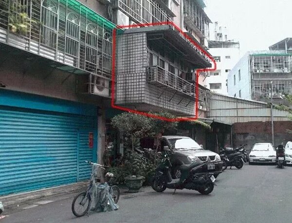 新莊新泰路一處老舊公寓二樓在陽台搭蓋違建,懸掛在女兒牆上,引起附近民眾恐慌,擔心陽台崩落。圖/新北工務局提供
