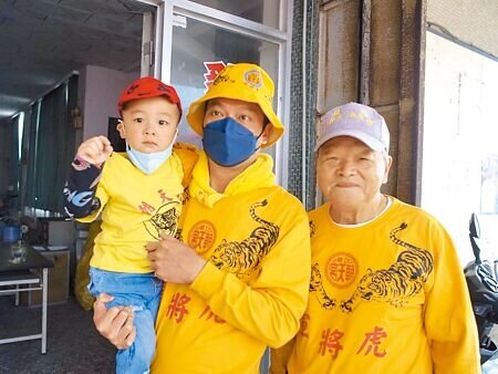 2歲幼兒蔡沅成(左)擔任虎爺轎班會爐主,參加雲林縣北港媽祖遶境成焦點。(張朝欣攝)