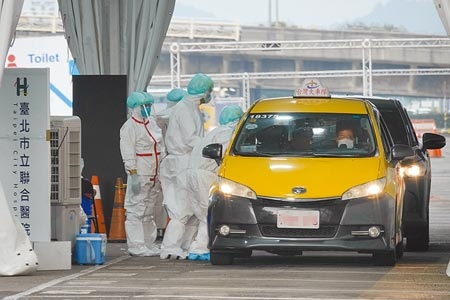 
疫情延燒，台北市大佳河濱公園車來速專案採檢現場，25日陸續湧入不少車輛，由醫護人員對民眾採檢。（黃子明攝）
