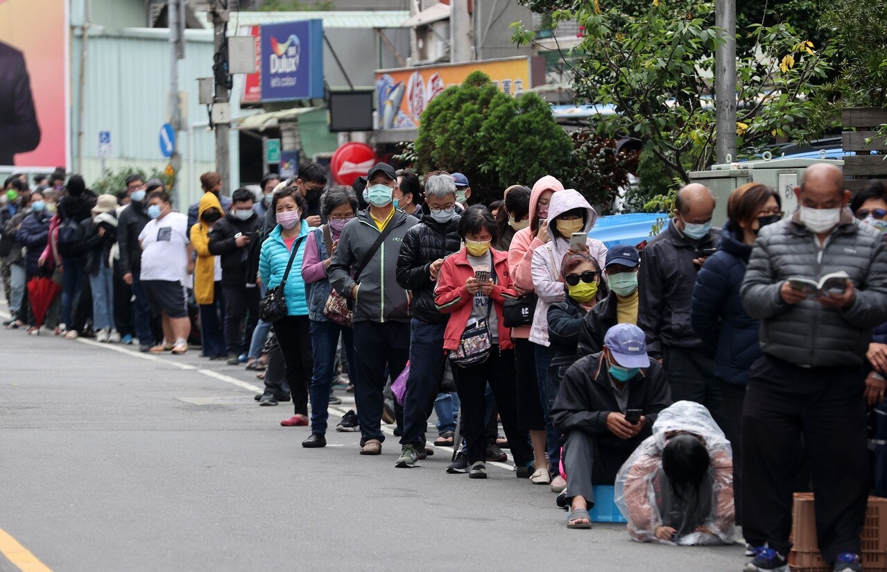 昨本土染疫人數逾兩萬三千，人人自危，新北市一家藥局外面，欲買快篩試劑民眾排隊人龍近百公尺。記者林澔一／攝影 