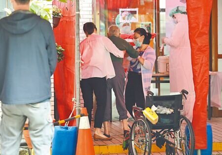 新冠疫情本土案例持續增加,各縣市篩檢站出現篩檢量能暴增,5日中和怡和積穗社區篩檢站(積穗市民活動中心)一位行動不便的年長者在家人扶持下完成篩檢。(陳俊吉攝)