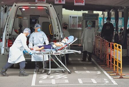 急診及社區篩檢站因確診者眾,工作量繁重也讓許多醫護疲憊不堪,指揮中心指揮官陳時中6日表示,目前安排190家基層診所加入,對於急診應能紓解,但還是再次提醒民眾,篩檢不要到急診。圖為一名患者在救護人員的協助下,用擔架推進急診室。(張鎧乙攝)