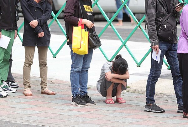 施景中表示,醫院為收治確診寶寶,恐壓縮其他重症兒童的醫療需求,是該滾動式檢討。圖為孩童跟著大人排隊等快篩。記者葉信菉/攝影